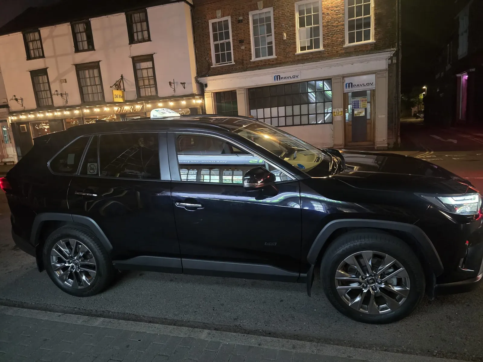 Kash Taxi's black Toyota RAV4 parked on a street in Abingdon at night